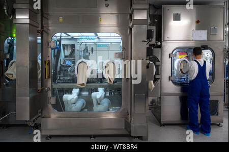 11 settembre 2019, Sassonia-Anhalt, Dessau-Roßlau: un dipendente di Oncotec Pharma produzione sta lavorando su una nuova linea per il riempimento sterile di farmaci contro il cancro. Il produttore di elementi essenziali di cancro e malattie autoimmuni farmaci attualmente impiega circa 300 persone all'Dessau-Roßlau BioPharmaPark ed ora ha investito 35 milioni di euro in nuovi impianti. Foto: Hendrik Schmidt/dpa-Zentralbild/ZB Foto Stock