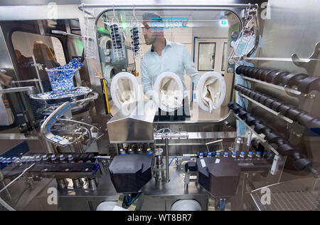 11 settembre 2019, Sassonia-Anhalt, Dessau-Roßlau: un dipendente di Oncotec Pharma produzione sta lavorando su una nuova linea per il riempimento sterile di farmaci contro il cancro. Il produttore di elementi essenziali di cancro e malattie autoimmuni farmaci attualmente impiega circa 300 persone all'Dessau-Roßlau BioPharmaPark ed ora ha investito 35 milioni di euro in nuovi impianti. Foto: Hendrik Schmidt/dpa-Zentralbild/ZB Foto Stock