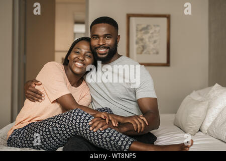 African American giovane seduto sul loro letto la mattina Foto Stock