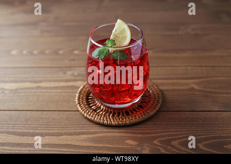 Bicchiere di tè freddo drink rosso closeup isolato sul tavolo Foto Stock