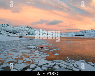 Antenna fuco panorama foto. Bel tramonto oltre le montagne e il mare delle isole Lofoten. Reine, Norvegia. Paesaggio invernale con colori eccezionali. Foto Stock