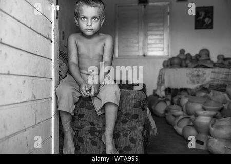 Ragazzo seduto sul lettino al quilombo Muquem Foto Stock