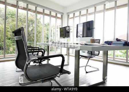 Ufficio moderno spazio interno con piante, tavolo in metallo, tappeto beige  e muro grigio Foto stock - Alamy