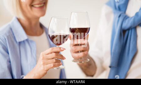 Coppia matura il tintinnio di bicchieri di vino rosso Foto Stock