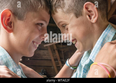 Gemelli sorridente testa a testa Foto Stock