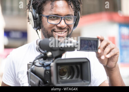 Il cameraman TV lavora nelle strade Foto Stock