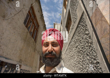 La religione sikh indossando turbante rosso intorno a Leh strade Foto Stock