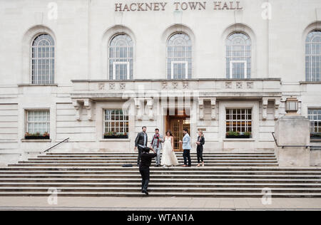 Un giovane, contemporanea party di nozze lasciare Hackney Town Hall, East London, Regno Unito. Foto Stock