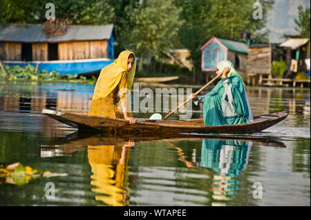 Old Lady pagaie piccola barca accompagnato da sua figlia su dal lago Foto Stock