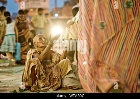 Vecchia donna a mendicare per le strade di Varanasi Foto Stock