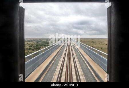 Nairobi. Decimo Sep, 2019. Un treno di test viene eseguito su un ponte ferroviario lungo il parco nazionale di Nairobi in Kenya, Sett. 10, 2019. La costruzione della ferrovia (SGR) fase 2 un progetto di collegamento del Kenya Nairobi capitale per la cittadina di Naivasha è entrato nella fase finale e di quello di un mese di prova è stata lanciata a partire da settembre, secondo il costruttore in Cina comunicazioni Costruzioni (CCC) Martedì. Credito: Zhang Yu/Xinhua/Alamy Live News Foto Stock