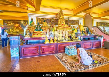 BANGKOK, Tailandia - 24 Aprile 2019: la giovane donna pregare sul tappeto e le donazioni nella casella all'altare di Wat Saket tempio, il 24 aprile ho Foto Stock