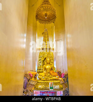 BANGKOK, Tailandia - 24 Aprile 2019: la piccola scultura del Signore Buddha seduto sopra il golden chedi entrambi coperti con incollata foglie d'oro, su Apri Foto Stock