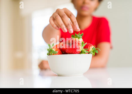 Close up della giovane donna di mangiare fragole fresche Foto Stock