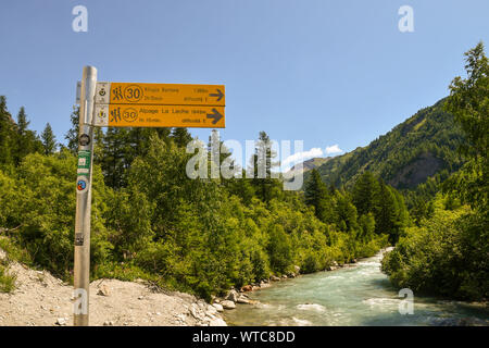 Vista del fiume Dora in Val Ferret valley con un segno che indica il Rifugio Bertone e La Leche rifugio alpino, Courmayeur, Aosta, Alpi, Italia Foto Stock