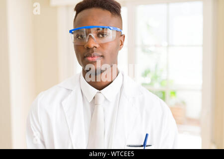 Africa scienziato giovane uomo che indossa gli occhiali di sicurezza lavorando con apparecchiature chimiche Foto Stock