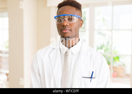 Africa scienziato giovane uomo che indossa gli occhiali di sicurezza lavorando con apparecchiature chimiche Foto Stock