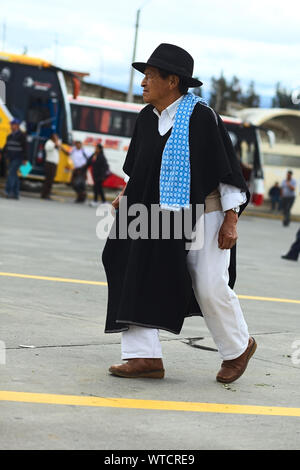 AMBATO, ECUADOR - 12 Maggio 2014: l'uomo non identificato in abiti tradizionali a piedi al terminal degli autobus su 12 Maggio 2014 in Ambato, Ecuador. Foto Stock