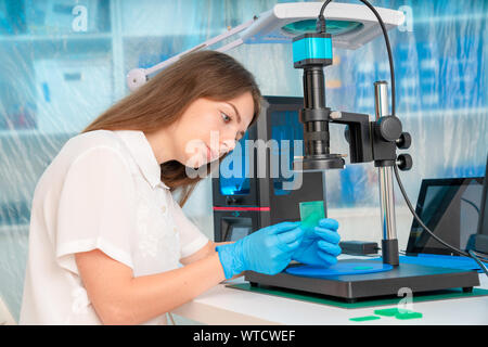 Lavoratore di sesso femminile nel controllo di resina LCD / DLP / SLA stampante 3D nel laboratorio di tecnologia Foto Stock