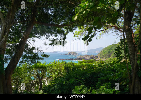 Bella e soleggiata spiaggia di Ixtapa zihuatanejo attraverso gli alberi e piante 2 Foto Stock