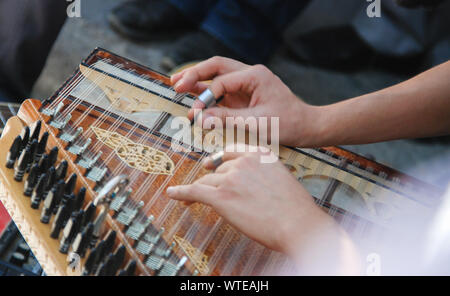 Due mani playing Qanon turco strumento musicale. Messa a fuoco selettiva. Foto Stock