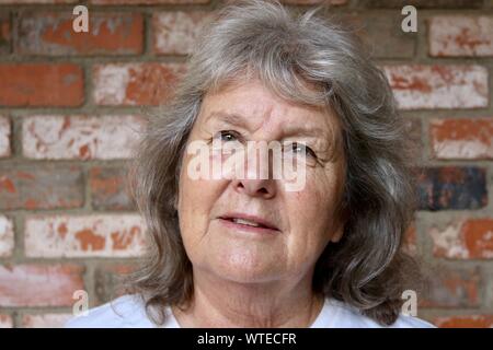 Ritratto di una donna anziana con i capelli grigi cercando la speranza Foto Stock