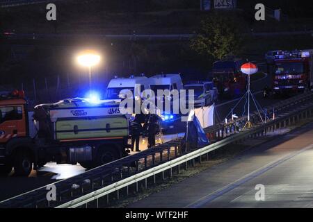 11 settembre 2019, Germania (tedesco), Berlino/Brandeburgo: poliziotti sono in piedi alla Hellersdorf svincolo sulla A10 nord-est di Berlino sulla carreggiata. Un uomo è stato mortalmente ferito da colpi sparati dalla polizia nel corso di un veicolo di polizia il controllo in anello di Berlino mercoledì. (Su 'sospettato reo shot mentre sotto il controllo di polizia") Foto: Christopher Harms/dpa Foto Stock