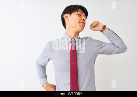 Businessman cinesi che indossa cravatta elegante in piedi isolato su sfondo bianco che risale, stanco e rilassato, assonnato e sbadigliante per primi morni Foto Stock