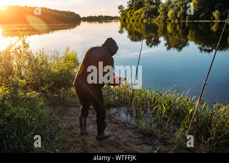 Pescatore pescato il pesce grande carpa in mattinata. Foto Stock