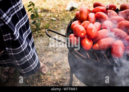 Pomodori di tostatura su un fuoco aperto in Guatemala Foto Stock
