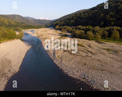 Volo di antenna con drone su belle montagne verdi e il fiume. Foto Stock