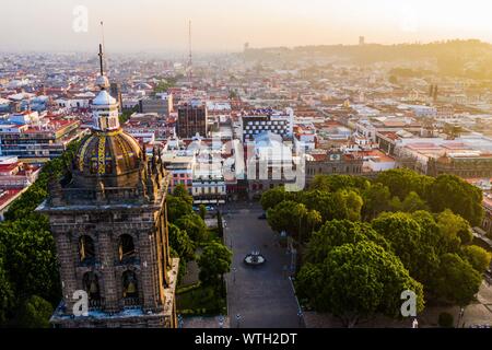 Puebla city pass a sunrise e vista aerea della Basilica o Cattedrale di Nostra Signora dell Immacolata Concezione, è la sede episcopale dell arcidiocesi di storici e di zocalo centro di Puebla, Messico. Essi hanno tradizioni messicane: gastronomia, architettura coloniale e la ceramica. Dipinto piastrelle talavera adornano edifici antichi. La cattedrale di Puebla, in stile rinascimentale, ha un alto campanile che si affaccia al Zocalo, la piazza centrale o Zocalo. Ho immettere storico. L'architettura è un sito Patrimonio Mondiale dell'UNESCO. Attrazioni turistiche: la Cattedrale, il Tempio della Madonna della concordia, ex Carolino Foto Stock