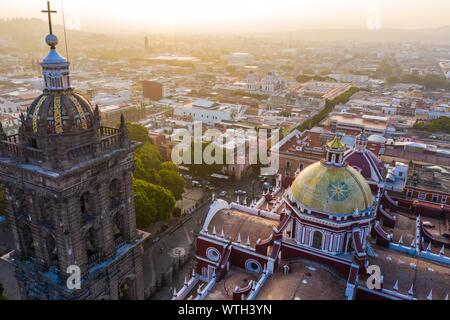 Puebla city pass a sunrise e vista aerea della Basilica o Cattedrale di Nostra Signora dell Immacolata Concezione, è la sede episcopale dell arcidiocesi di storici e di zocalo centro di Puebla, Messico. Essi hanno tradizioni messicane: gastronomia, architettura coloniale e la ceramica. Dipinto piastrelle talavera adornano edifici antichi. La cattedrale di Puebla, in stile rinascimentale, ha un alto campanile che si affaccia al Zocalo, la piazza centrale o Zocalo. Ho immettere storico. L'architettura è un sito Patrimonio Mondiale dell'UNESCO. Attrazioni turistiche: la Cattedrale, il Tempio della Madonna della concordia, ex Carolino Foto Stock