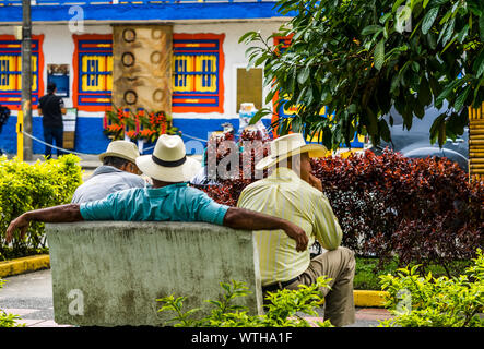 Popolo della Colombia, gruppo di vecchio uomo seduto sul banco in colorate strade del villaggio Filandia Foto Stock