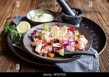 Insalata di verdure con il rosso e bianco cicoria, trota al forno pezzi, cipolla e arrosto di Hokkaido squash, servito con panna acida dip Foto Stock