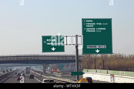 Autostrada italiana con cartelli stradali e più direzioni di città italiane Foto Stock