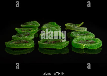 Sacco di fette di dolci verdi canditi di kiwi isolato sul vetro nero Foto Stock