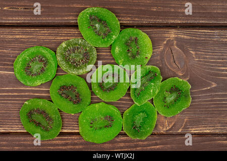 Sacco di fette di dolci verdi canditi di kiwi flatlay su legno marrone Foto Stock