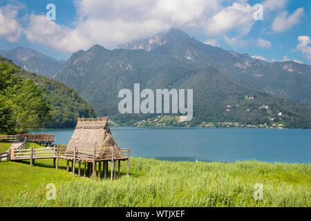 Il Lago di Ledro tra le Alpi del Trentino distretto con la casa di epoca preistorica. Foto Stock