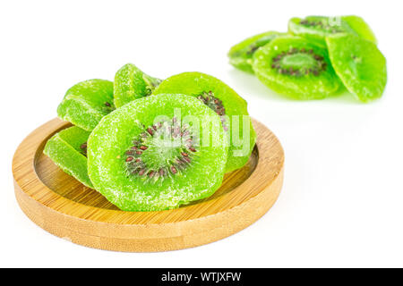 Sacco di fette di dolci verdi canditi di kiwi sul bambù coaster isolati su sfondo bianco Foto Stock