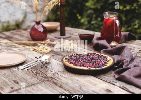 Torta di bacche con ciliegia, ribes, mora, mirtillo sul tavolo in legno in stile rustico . In casa la cheesecake. Foto Stock
