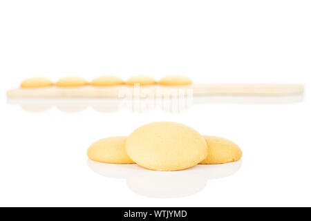 Gruppo di otto tutto il dolce e dorato biscotto di spugna sul piccolo tagliere di legno isolato su sfondo bianco Foto Stock