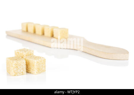 Gruppo di otto intera sweet Brown Sugar Cube sul piccolo tagliere di legno isolato su sfondo bianco Foto Stock