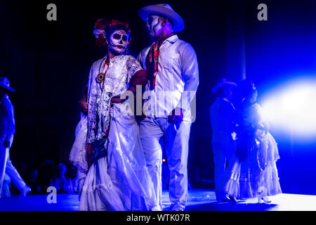 Merida, Messico - 27 Ottobre 2018: Balli Catrina coppie con cranio compongono per dias de los Muertos con abiti tradizionali a Remate de Paseo Montejo al Festival de las animas Foto Stock