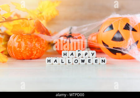 Halloween sfondo arancione con blocchi di parola happy Halloween decorazioni e zucca jack o lantern divertente spider spooky web e ragno nero su bianco Foto Stock