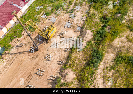 Palo di fondazione driver machine. costruzione macchine sul sito in costruzione. foto aerea da flying drone Foto Stock