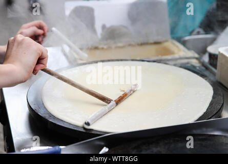 Berlino, Germania. Decimo Sep, 2019. Un membro del personale allarga la farina in un recipiente per preparare crêpe in una fase di stallo a Berlino, capitale della Germania, il 7 settembre 10, 2019. Sebbene nata in Francia, crêpe è stato uno dei più famosi stuzzichini in Germania. Credito: Shan Yuqi/Xinhua/Alamy Live News Foto Stock