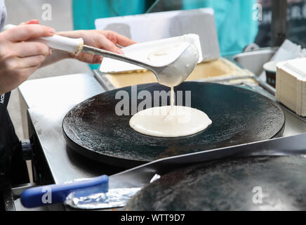 Berlino, Germania. Decimo Sep, 2019. Un membro del personale versa la farina in un recipiente per preparare crêpe in una fase di stallo a Berlino, capitale della Germania, il 7 settembre 10, 2019. Sebbene nata in Francia, crêpe è stato uno dei più famosi stuzzichini in Germania. Credito: Shan Yuqi/Xinhua/Alamy Live News Foto Stock