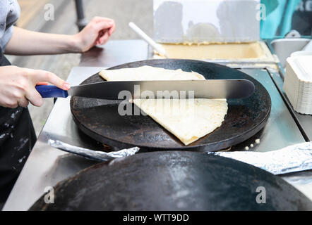 Berlino, Germania. Decimo Sep, 2019. Un membro del personale rende segni di piegatura su un quasi finito crêpe in una fase di stallo a Berlino, capitale della Germania, il 7 settembre 10, 2019. Sebbene nata in Francia, crêpe è stato uno dei più famosi stuzzichini in Germania. Credito: Shan Yuqi/Xinhua/Alamy Live News Foto Stock