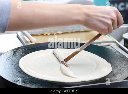 Berlino, Germania. Decimo Sep, 2019. Un membro del personale allarga la farina in un recipiente per preparare crêpe in una fase di stallo a Berlino, capitale della Germania, il 7 settembre 10, 2019. Sebbene nata in Francia, crêpe è stato uno dei più famosi stuzzichini in Germania. Credito: Shan Yuqi/Xinhua/Alamy Live News Foto Stock